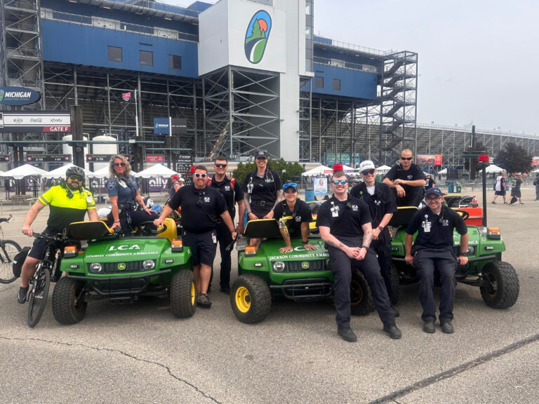 Paramedics on bikes and medical response vehicles at an outdoor event.